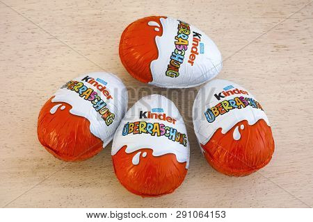 Paphos, Cyprus - November 21, 2016 Four Kinder Surprise Eggs On Wooden Background. Word Surprise Wri