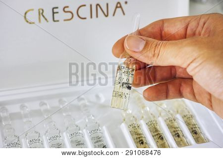 Paphos, Cyprus - November 13, 2015 Woman Hand With Ampoule Of Crescina Re-growth In Front Of Crescin