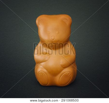 Chocolate Bear On Gark Green Background. Close-up.