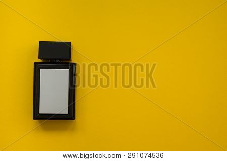 Perfume In Beautiful Black Bottle On A Yellow Background, Flat Compozition.