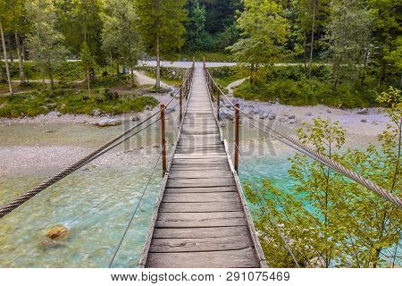 Swingbridge Over Blue Soca River Near Bovec In Triglav National Park, Slovenia, Europe.