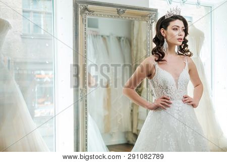 Beautifu bride choosing wedding dress in a wedding salon