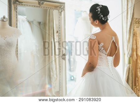 Beautifu bride choosing wedding dress in a wedding salon