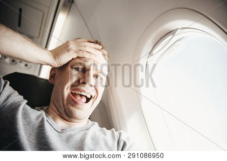 Male Passenger In Plane Screams And Cries, Aerophobia. Background Of Porthole. Concept Fear Of Flyin