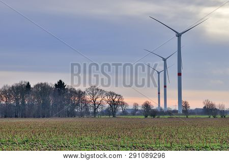 View On Alternative Energy Windmills In A Windpark In Northern Germany In Front Of A Blue Sky