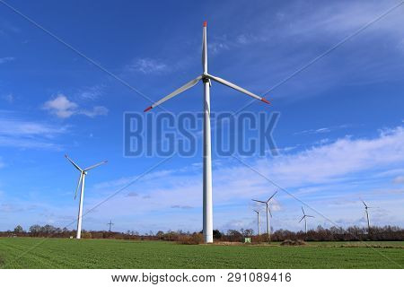 View On Alternative Energy Windmills In A Windpark In Northern Germany In Front Of A Blue Sky