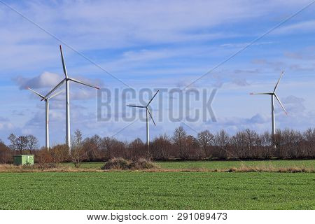 View On Alternative Energy Windmills In A Windpark In Northern Germany In Front Of A Blue Sky