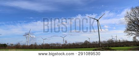 View On Alternative Energy Windmills In A Windpark In Northern Germany In Front Of A Blue Sky