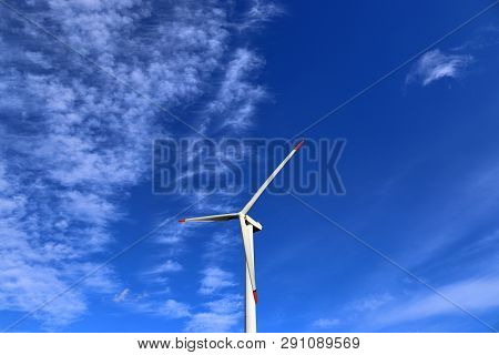 View On Alternative Energy Windmills In A Windpark In Northern Germany In Front Of A Blue Sky