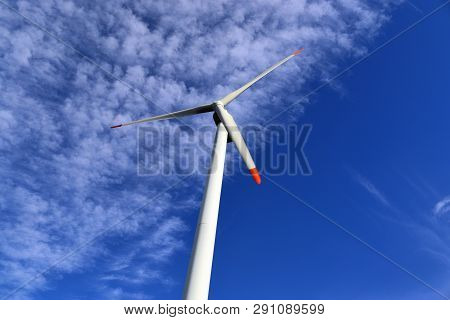 View On Alternative Energy Windmills In A Windpark In Northern Germany In Front Of A Blue Sky