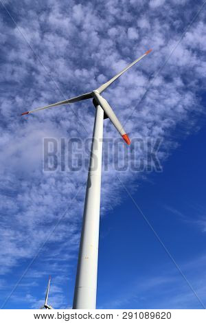 View On Alternative Energy Windmills In A Windpark In Northern Germany In Front Of A Blue Sky