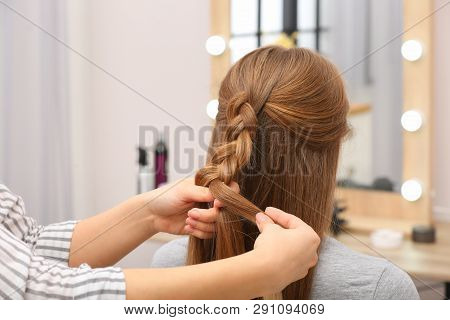 Professional Coiffeuse Braiding Client's Hair In Salon