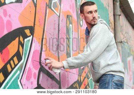 A Young Graffiti Artist Looks Around While Drawing. Vandal Tries