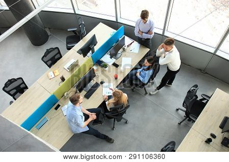 Top View Of Young Modern Colleagues In Smart Casual Wear Working Together While Spending Time In The
