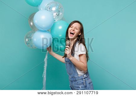 Funny Woman In Denim Clothes With Closed Eyes Sing Song In Microphone Celebrating, Holding Colorful 