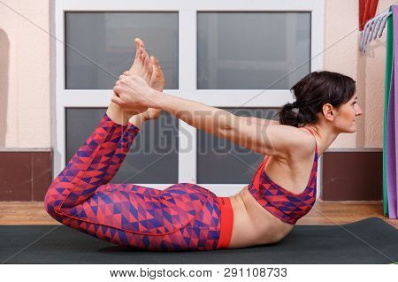 Young Sporty Woman Practicing Yoga, Doing Mahamudra Stretching Position In A Fitnes Club