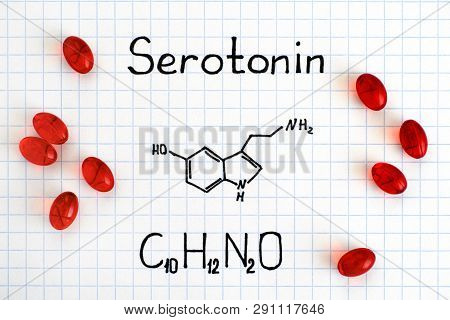 Chemical Formula Of Serotonin With Red Pills. Close-up.