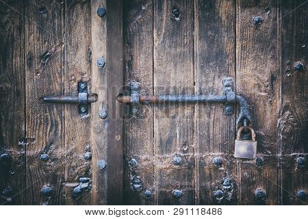 Wooden Door With Bolt And Padlock. Close-up.