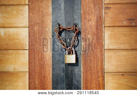 Wooden Door Closed By Chain And Padlock. Close-up.