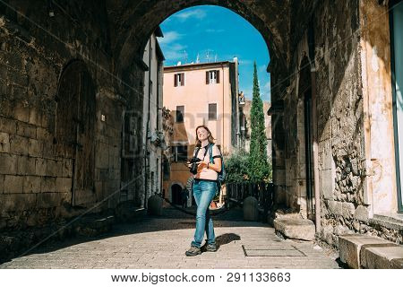 Terracina, Italy. Young Caucasian Woman Taking Photos In Gothic Palazzo Venditti.