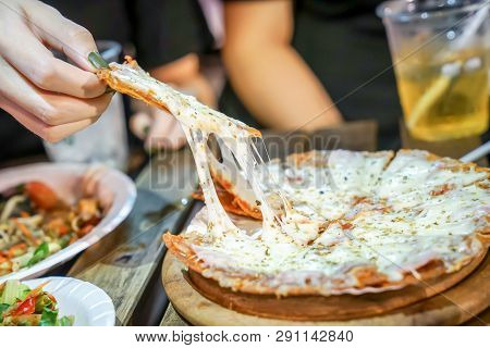 Woman's Hand Take Pizza Pices Out From Pizza Plate In Foodtruck Event, Cheese's Pizza Is Stretced By