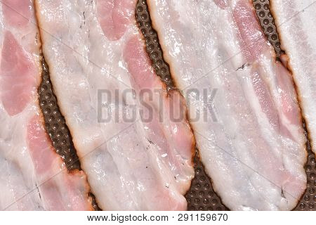 Bacon Is Fried In A Pan With A Non-stick Coating. Close-up. Bacon Strips Or Rashers Being Cooked In 