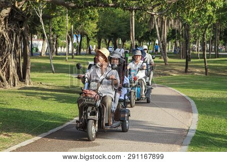 China, Hainan Island, Sanya Bay  - December 2, 2018: City Street, Chinese Electric Moped Tricycle, E