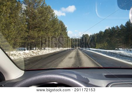 View Of The Road Through The Windshield. Snow On The Sidelines. Blue Sky With Clouds. Point Of View 