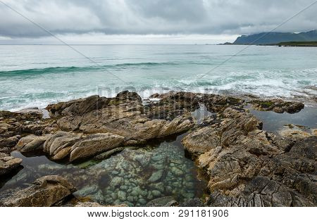 Summer Cloudy View Of The Beach With Pool In Middle Of Stones ( Ramberg, Norway, Lofoten).