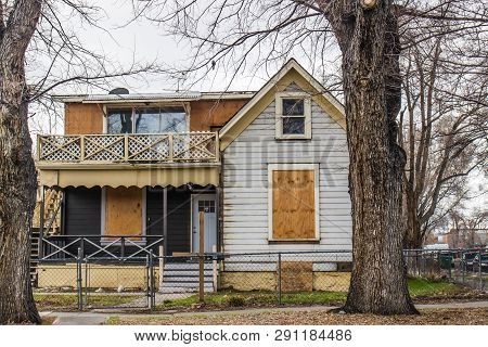 Abandoned Two Story Home With Boarded Up Windows