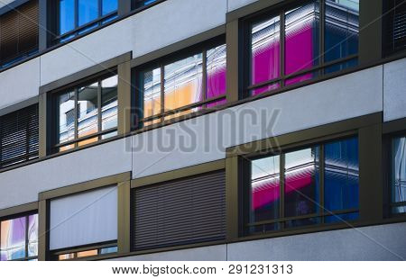 Reflections Of Colored Wall Of Opposite Building In Window Front