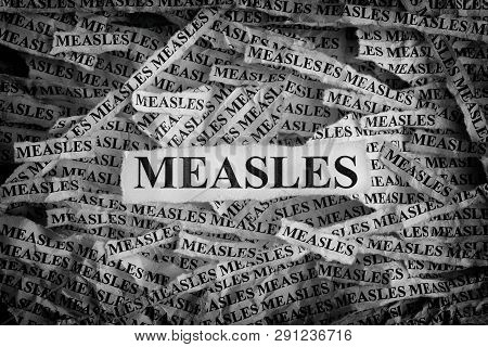 Measles. Torn Pieces Of Paper With The Words Measles. Concept Image. Black And White. Close Up.