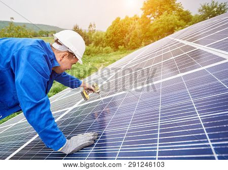 Construction Worker Connects Photo Voltaic Panel To Solar System Using Screwdriver. Professional Ins