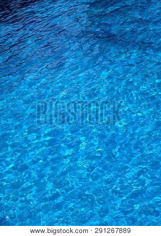 The Water Surface Of The Swimming Pool Turquoise Color, Illuminated By The Sun