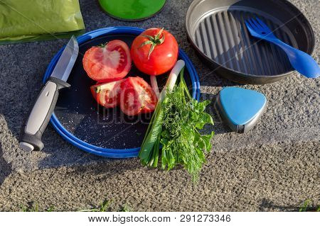 Tourist dishes and appliances. Cutting lettuce in nature.