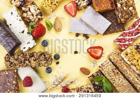 Assortment Of Different Granola Cereal Bars On Yellow Background. Healthy Pre Or Post Workout Snacks