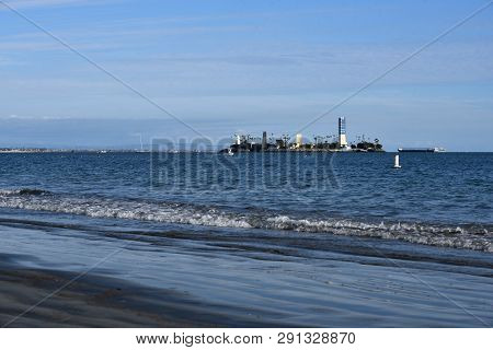 Water Coming To Shore And The Sand Is Noticably Dirty On Alamitos Beach From Offshore Oil Drilling