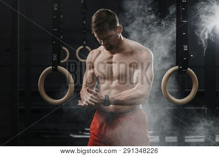Portrait Of Muscular Athlete Clapping Hands And Preparing For Workout At The Gym. Cloud Of Dust Chal