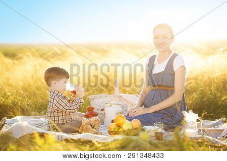 Cute Mom And Little Son Playing With My Teddy. Mother And Son Feeding Teddy Bear On A Picnic