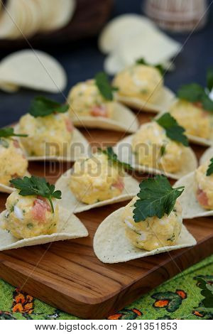 Appetizer On Chips With Salmon, Eggs And Cheese
