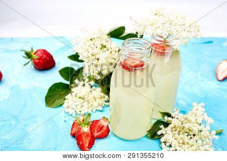 Kombucha Tea With Elderflower And Strawberry On Blue Background.