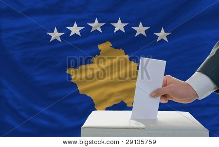 Man stemmer på valg foran nationale Flag af Kosovo