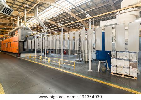 Powder Coating Line. Metal Panels Are Suspended On An Overhead Conveyor Line. Painting Products In A