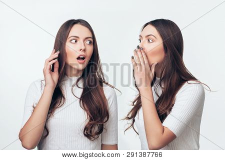 Two Sisters Twins Gossiping Isolated On White Background. Share Secret Concept