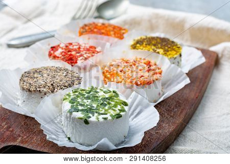Assortment Of French Fresh White Soft Goat Cheeses With Different Tastes Topping Made With Herbs, Pa