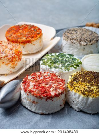 Assortment Of French Fresh White Soft Goat Cheeses With Different Tastes Topping Made With Herbs, Pa