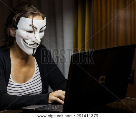 Pattaya, Thailand - November 17, 2015:
A Woman With Vendetta Mask In Front Of A Laptop. This Mask Is