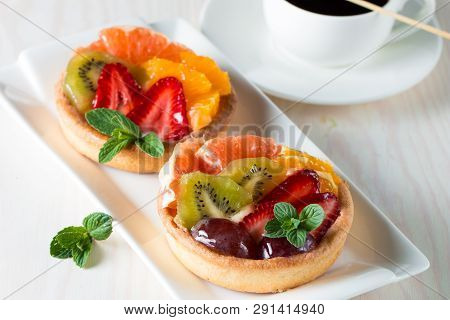 Fresh Fruit And Berry Tart Dessert With Toss Sugar On Wooden Background. Delicious Sweet Cake With R