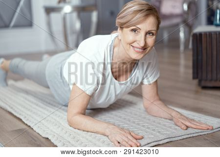 Female Enjoys Yoga. Her Age Is Over 50 Years Old. Yoga Helps A Female To Keep Herself In Shape.