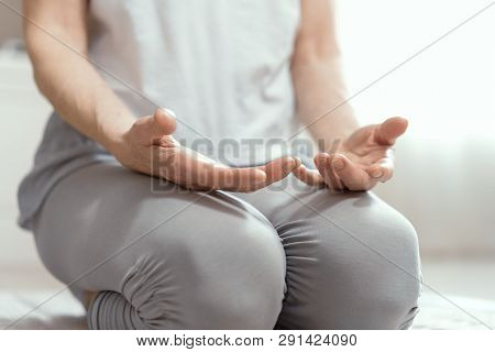 Adult Woman Does Yoga At Home. Her Hands On Her Legs. The Woman Took The Position Of Asana. Close Up
